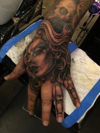 beautiful wicked female face tattoo on hand by Noe Lopez
